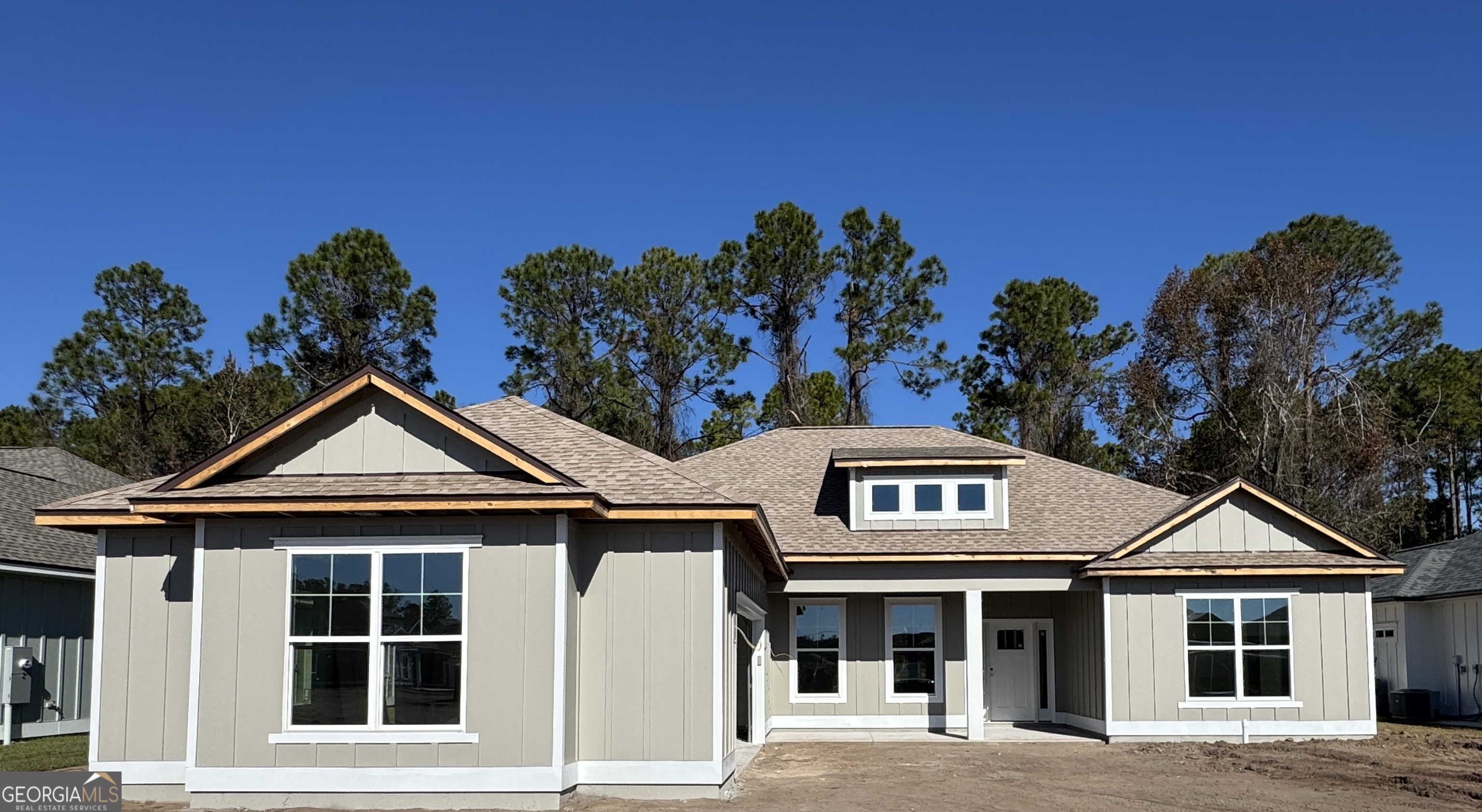 a front view of a house with plants and trees