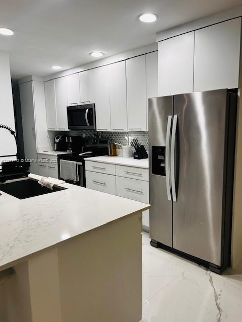 a kitchen with stainless steel appliances a refrigerator sink and microwave