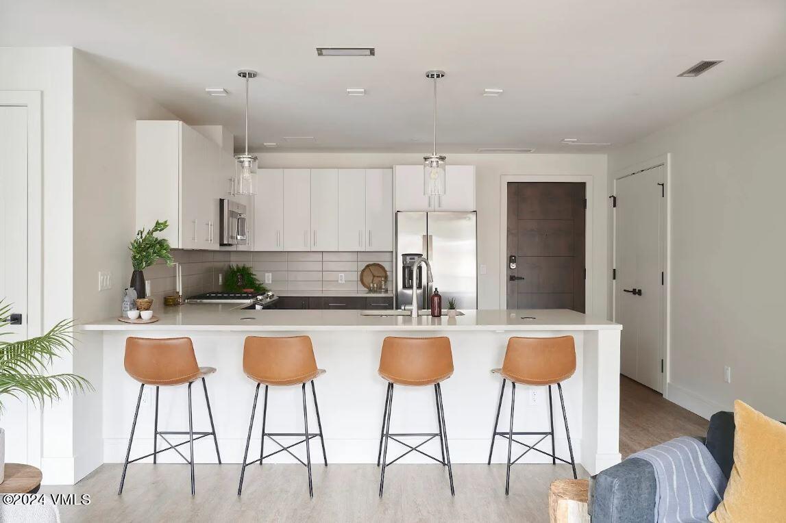 a kitchen with granite countertop white cabinets and stainless steel appliances