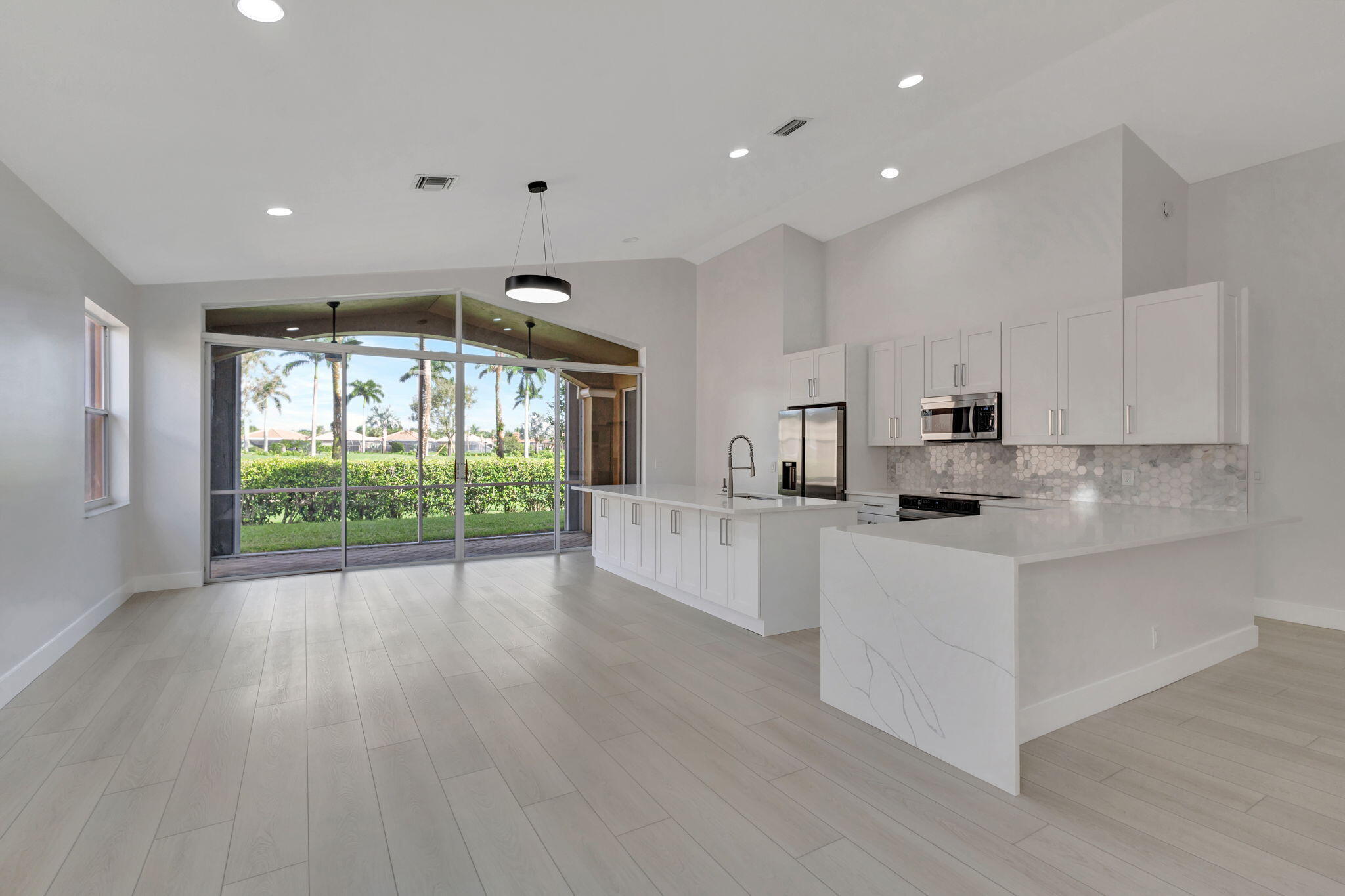 a large white kitchen with lots of counter space wooden floor and appliances