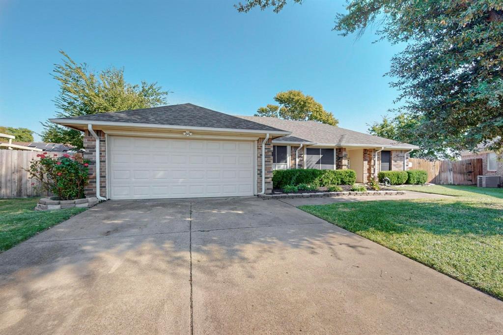 a front view of a house with a yard and a garage