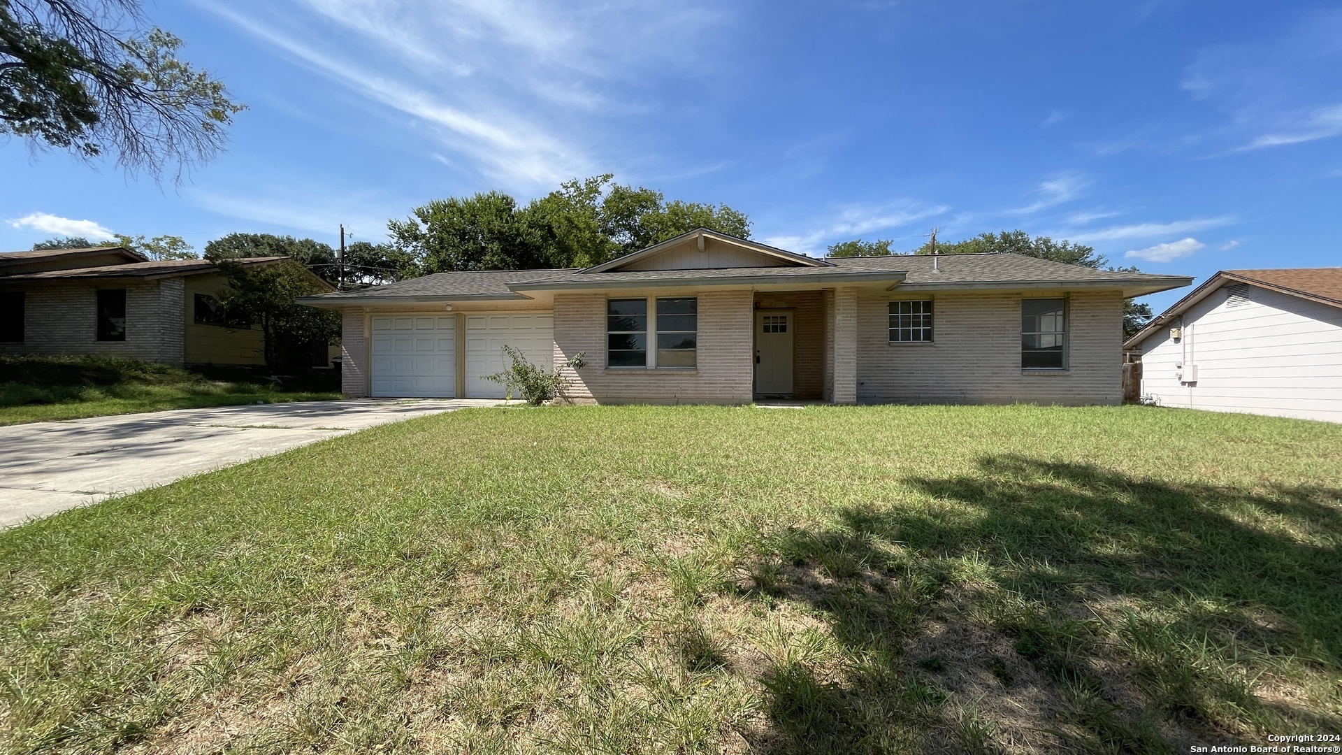 a front view of a house with yard and green space