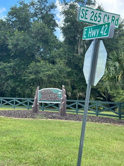 a view of a park that has a sign board large trees