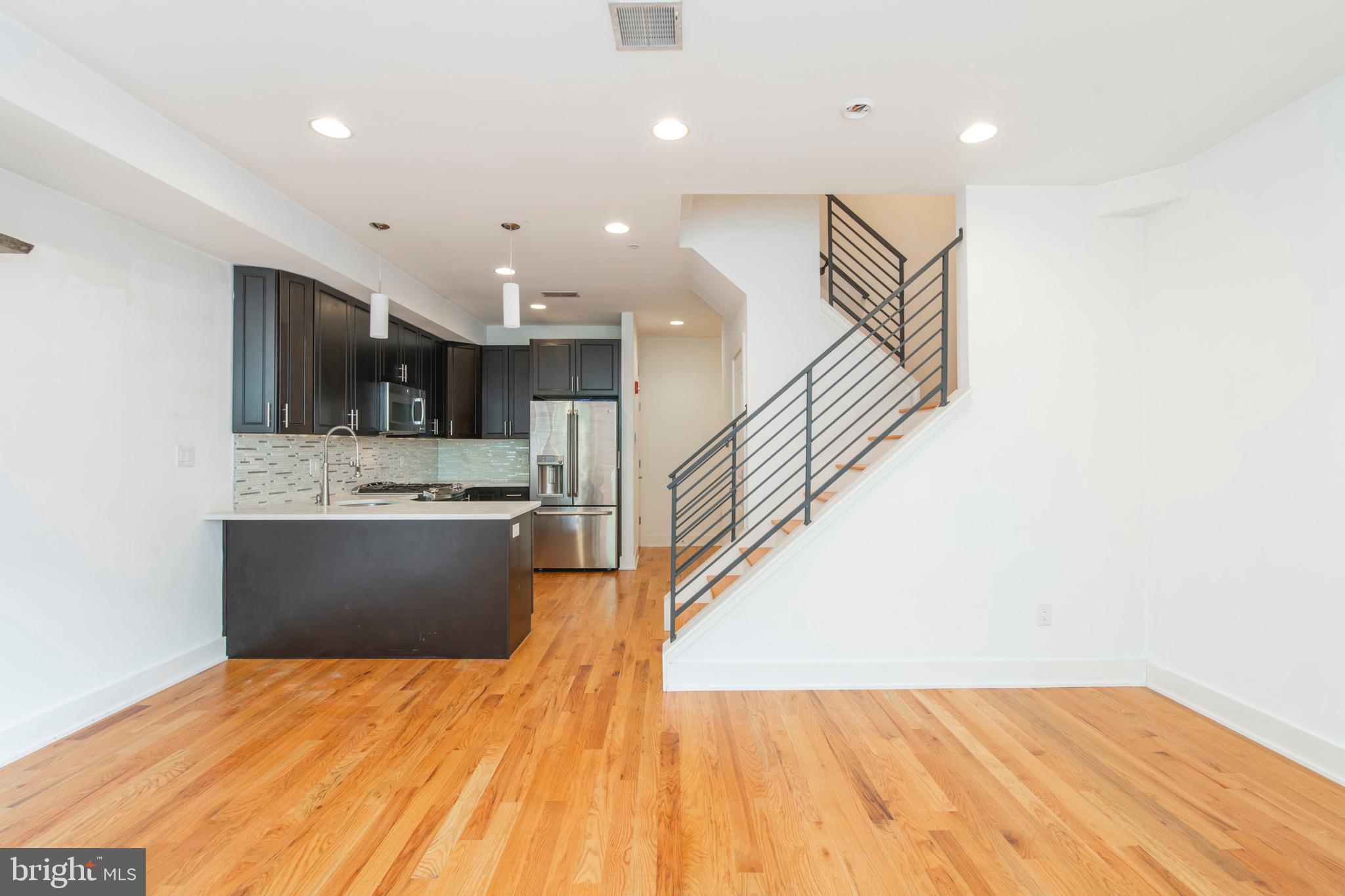 a view of kitchen and hall with wooden floor