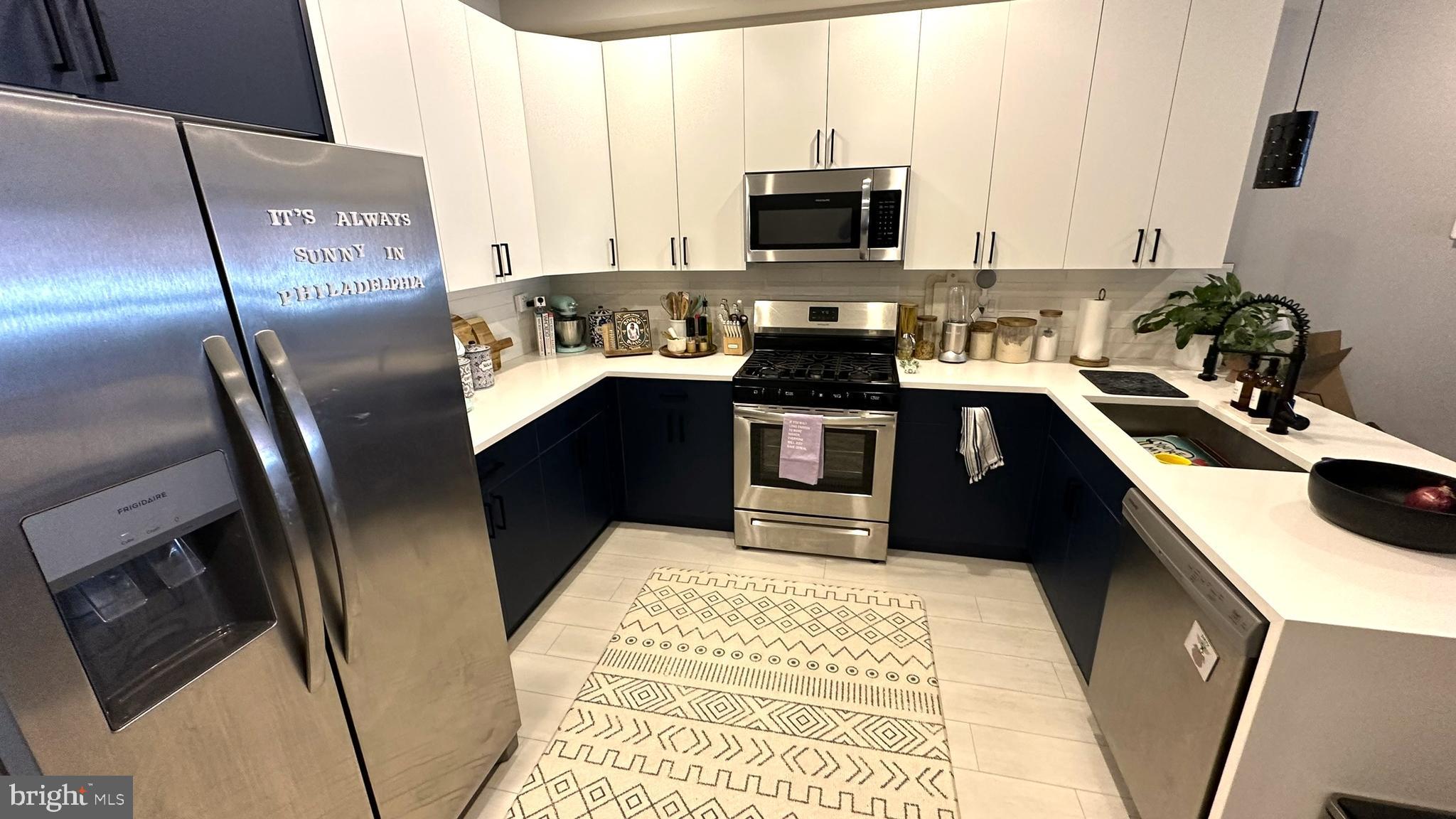 a kitchen with stainless steel appliances granite countertop a sink stove microwave and refrigerator