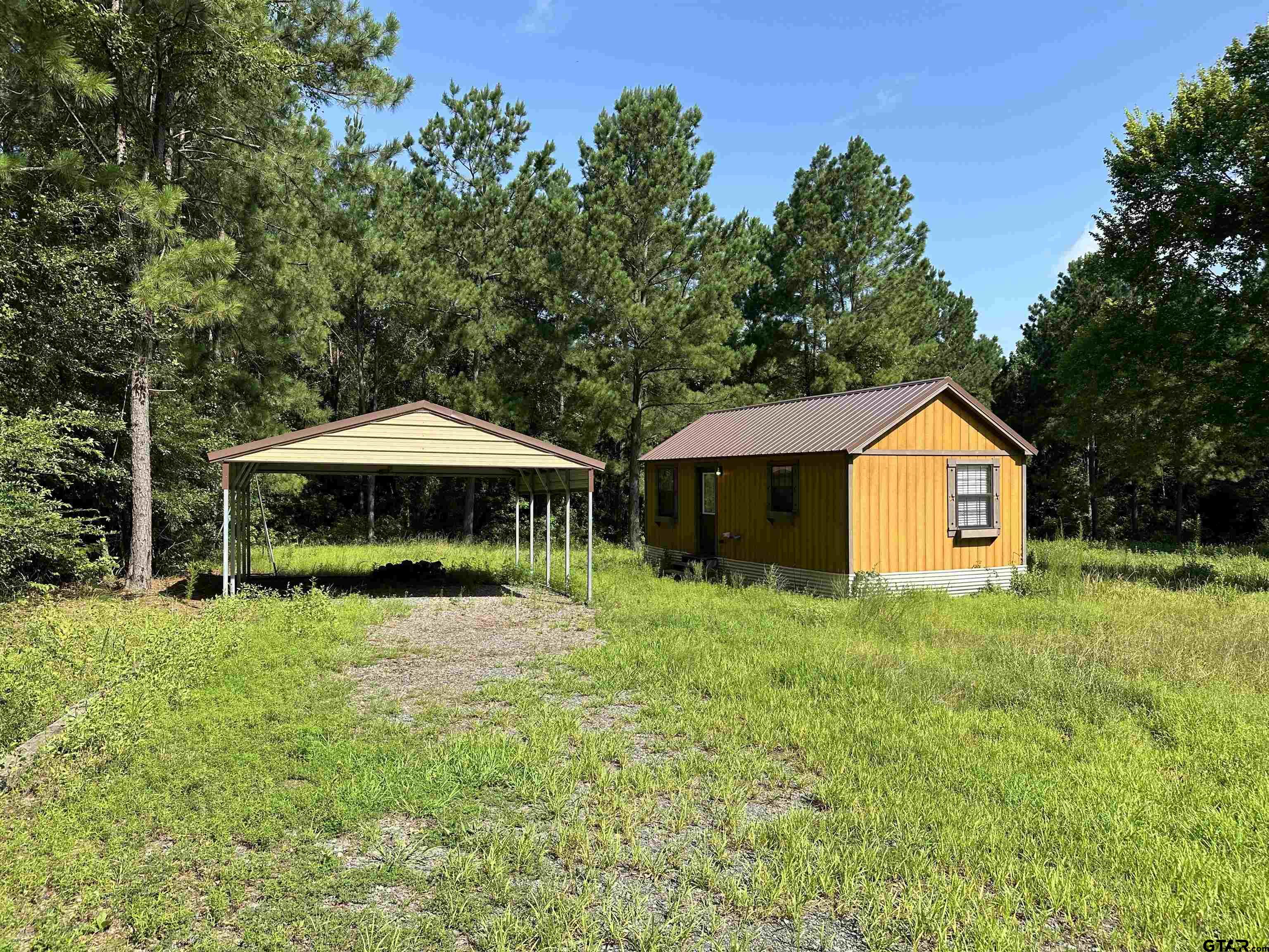 a yellow house in middle of the forest