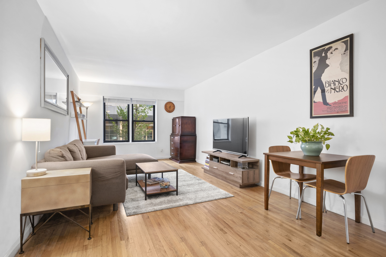 a living room with furniture a wooden floor and next to a window