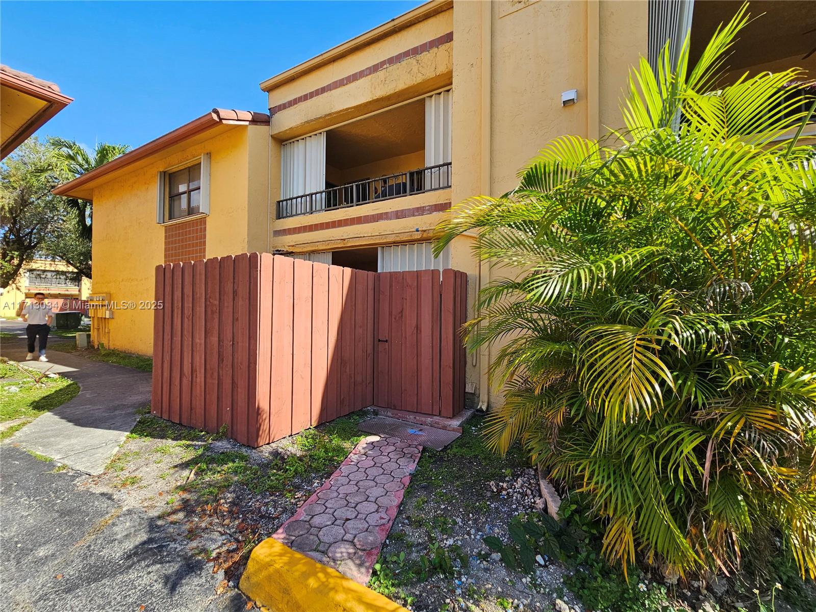 a backyard of a house with plants and wooden fence