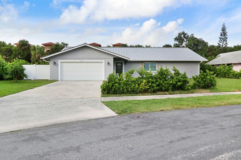 a view of a house with a yard and a garage