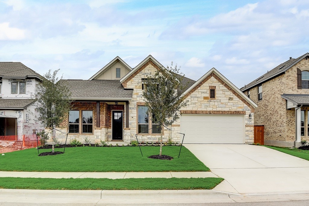 a front view of a house with a garden and plants