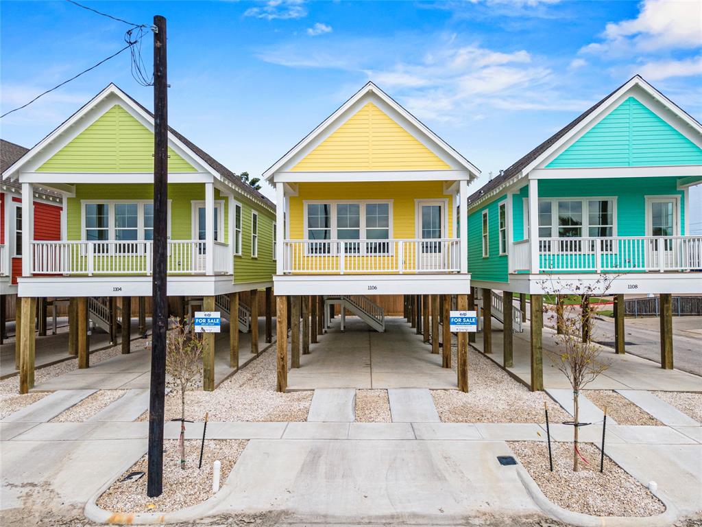 1106 is the Colorful yellow home which gives an elevated beach-style look with a front porch, featuring spacious under-home parking and modern design. Ideal for coastal living.