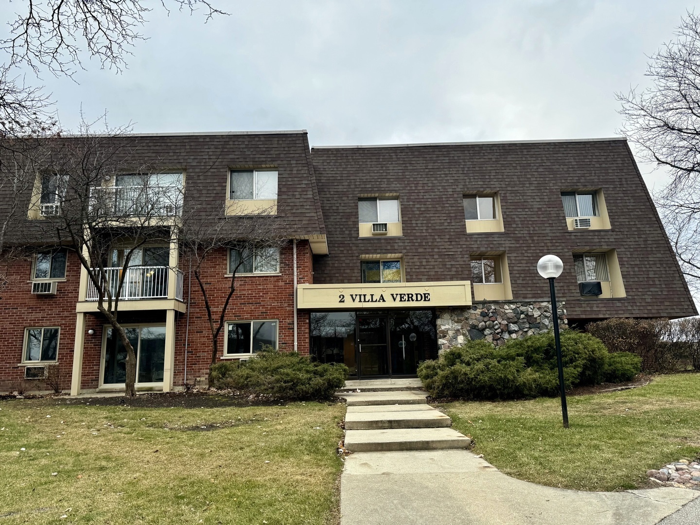 a front view of a residential apartment building with a yard