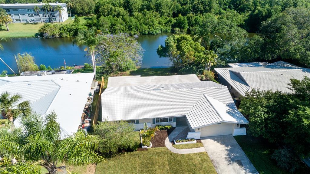 an aerial view of a house with a yard and lake view