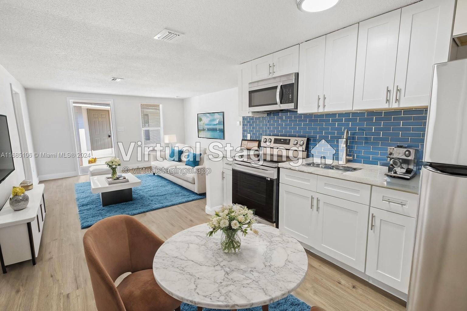 a kitchen with stainless steel appliances granite countertop a stove a sink a dining table and chairs