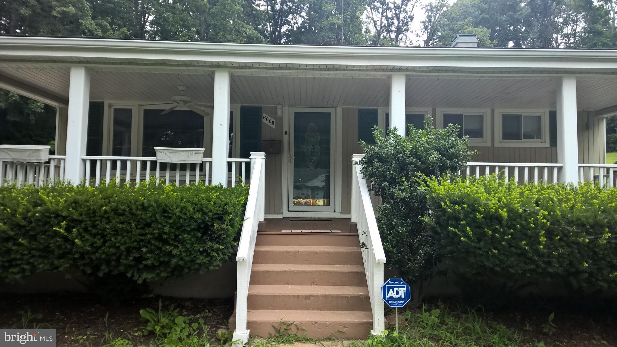 a front view of a house with plants and garden