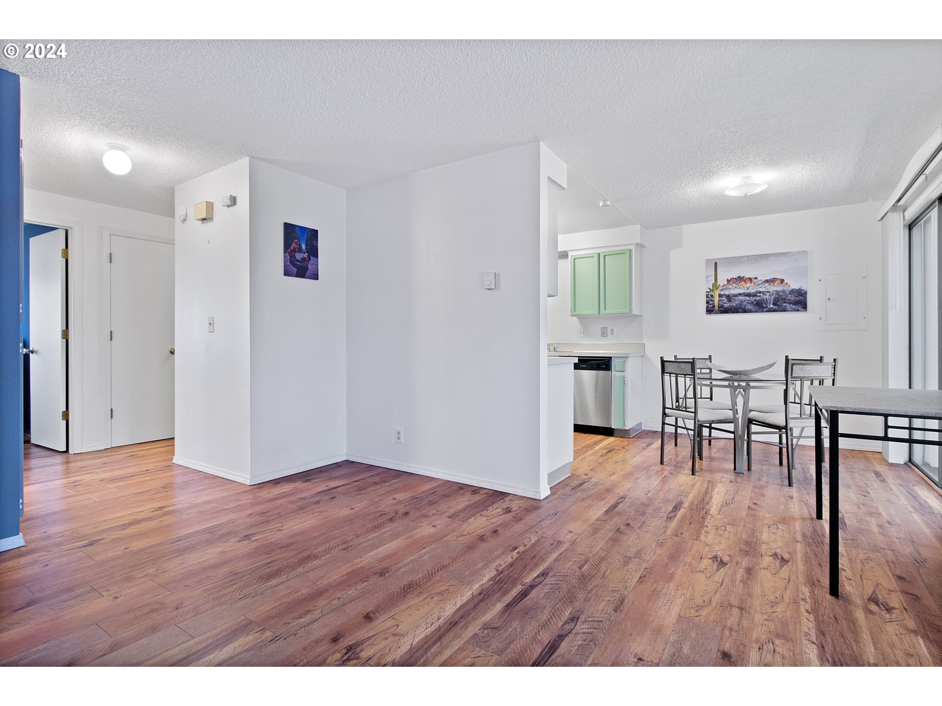 a view of empty room with wooden floor and furniture