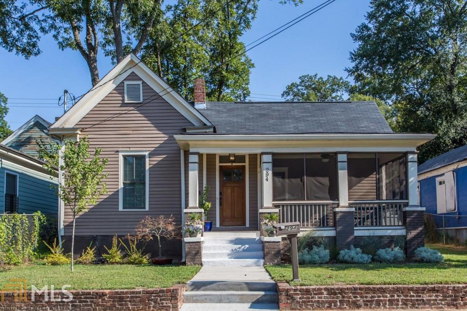 a front view of a house with a yard and potted plants