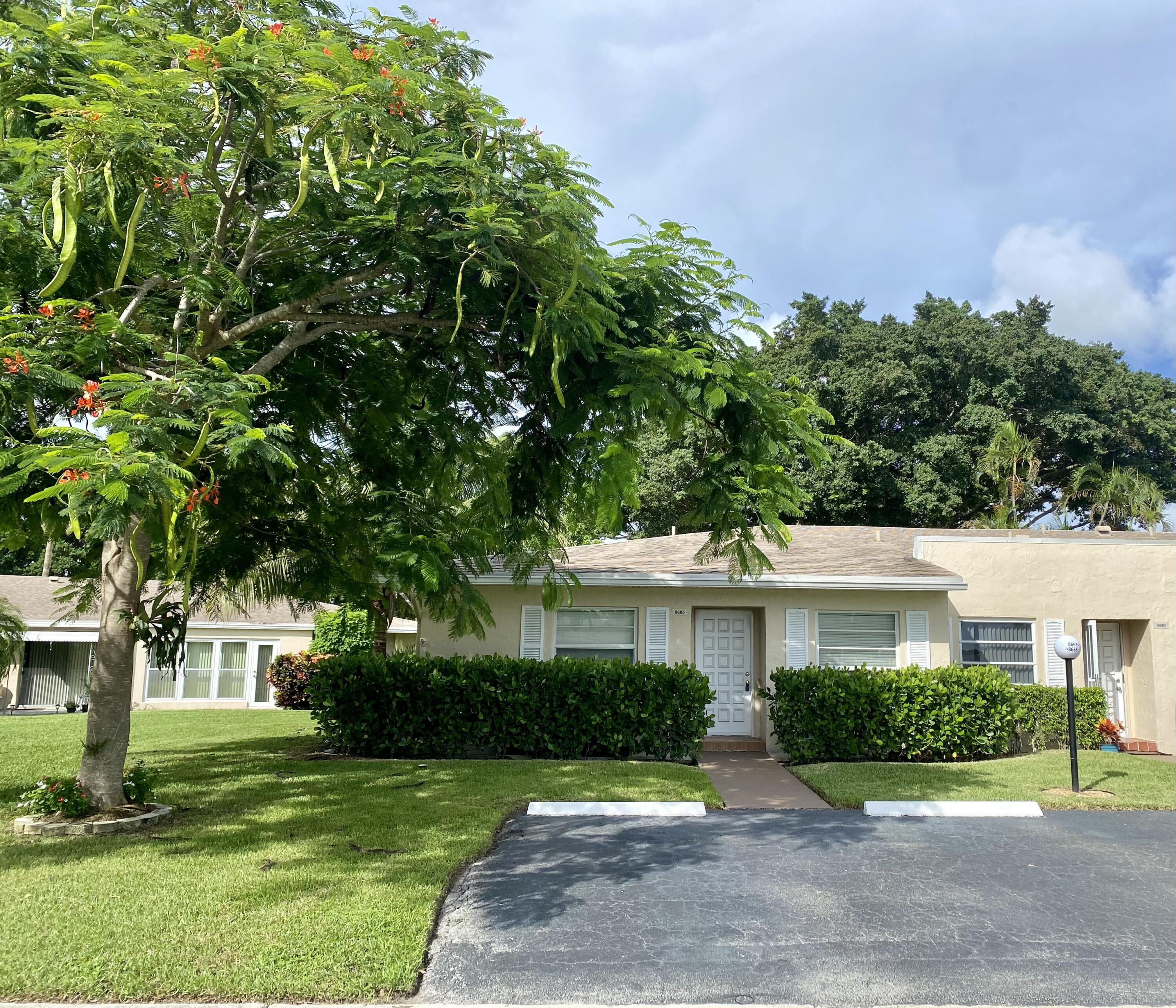 a front view of a house with a yard and potted plants