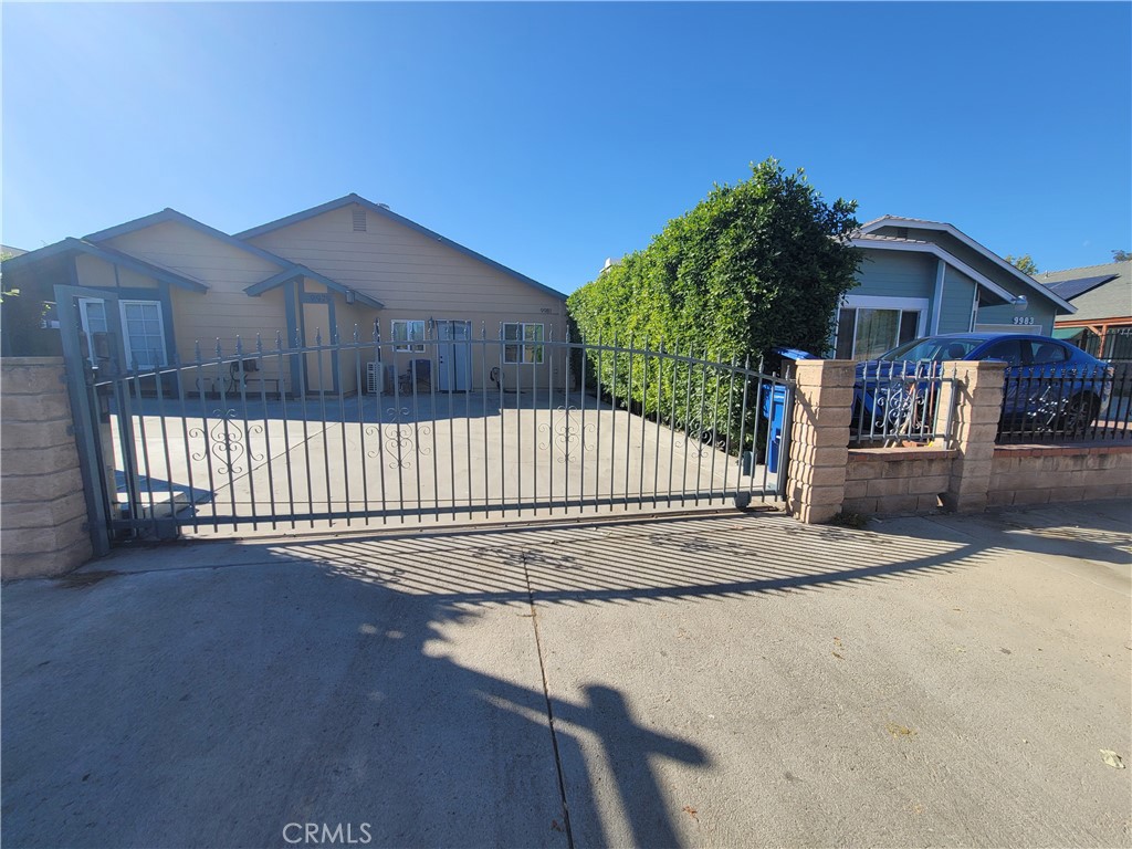 a view of a house with a small yard and wooden fence