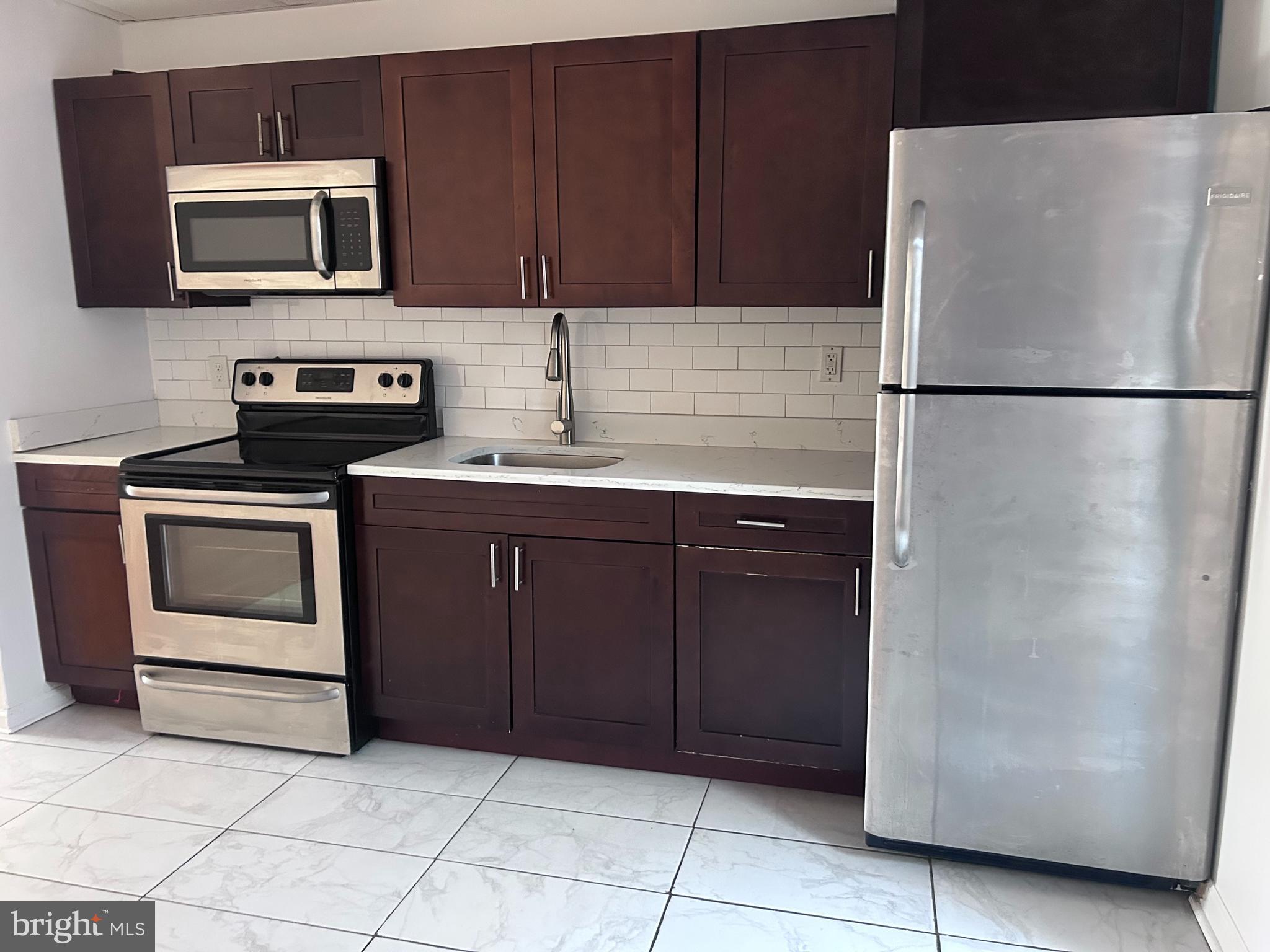 a kitchen with stainless steel appliances granite countertop a refrigerator and a microwave