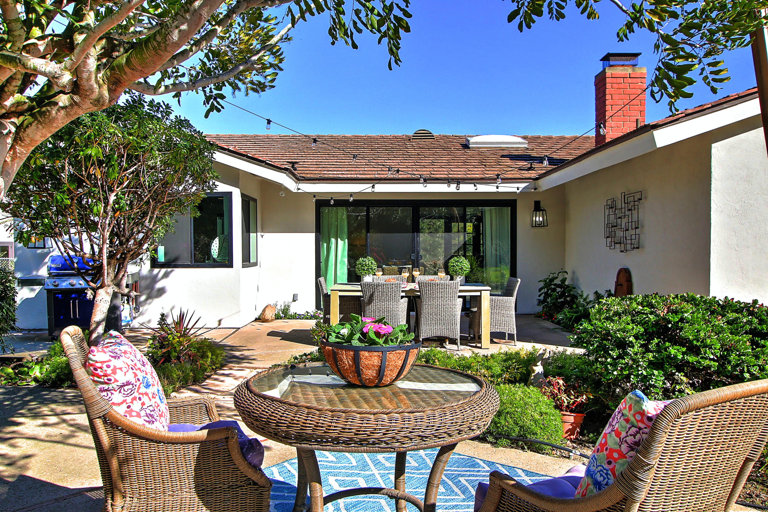 a view of a patio with couches table and chairs and potted plants