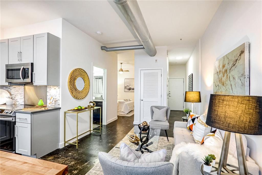 a living room with furniture a mirror and white walls