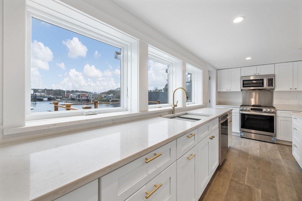 a large kitchen with kitchen island a large window in it