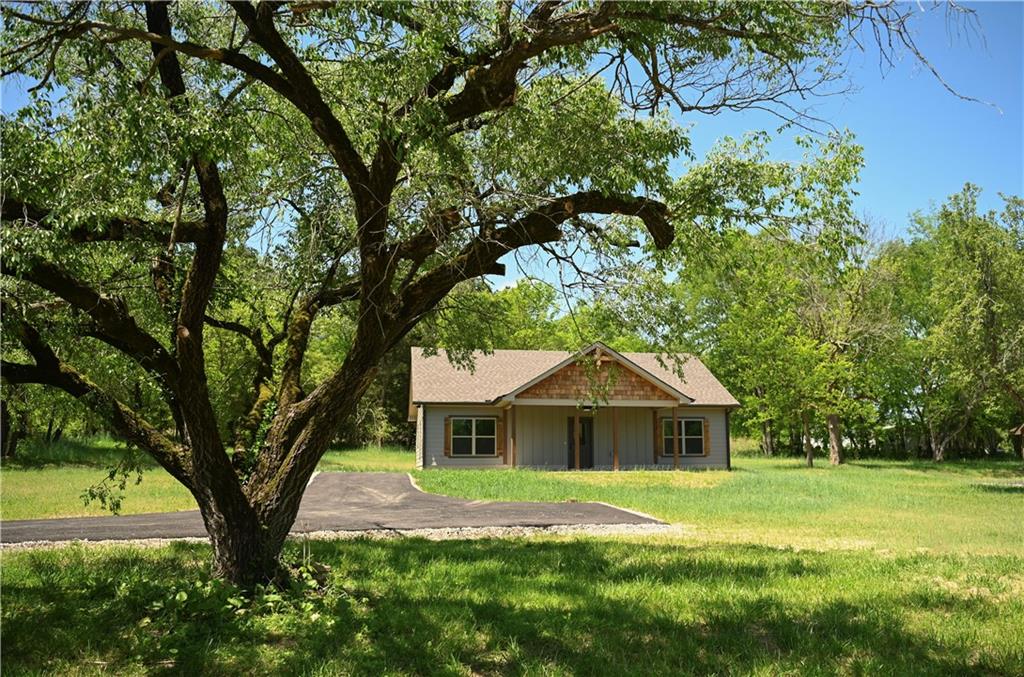 a front view of a house with yard and green space