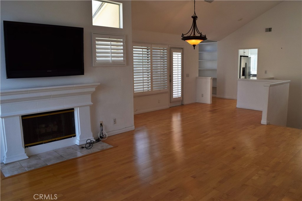 a view of an empty room with a fireplace and a window