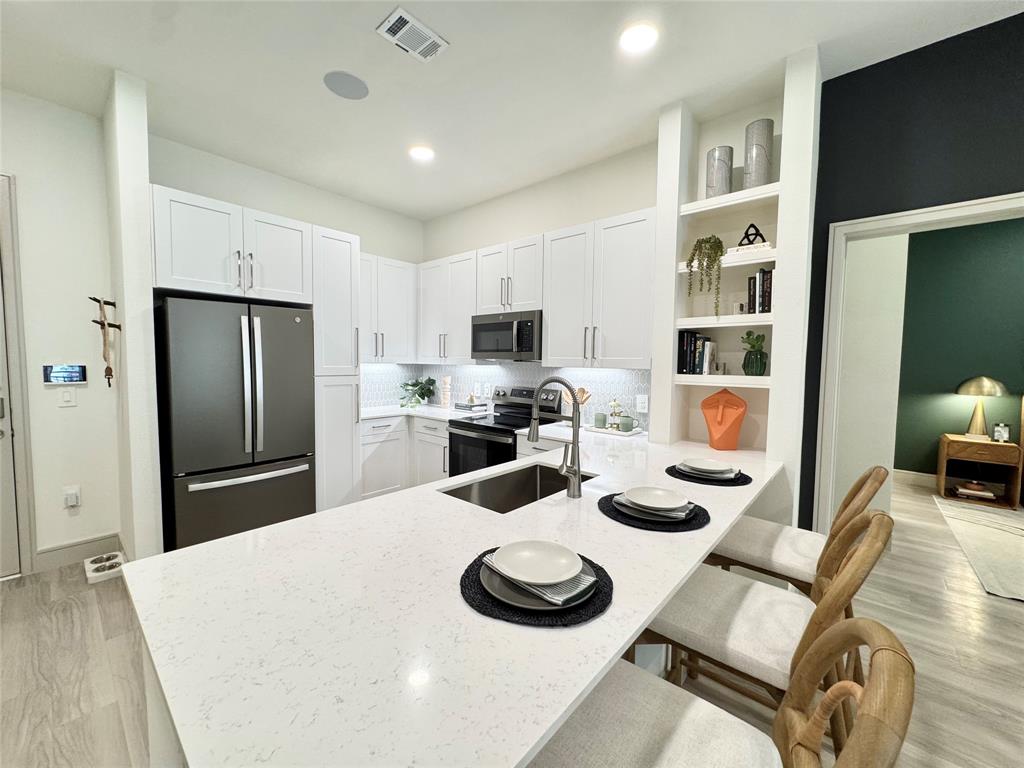 a kitchen with sink refrigerator and living room