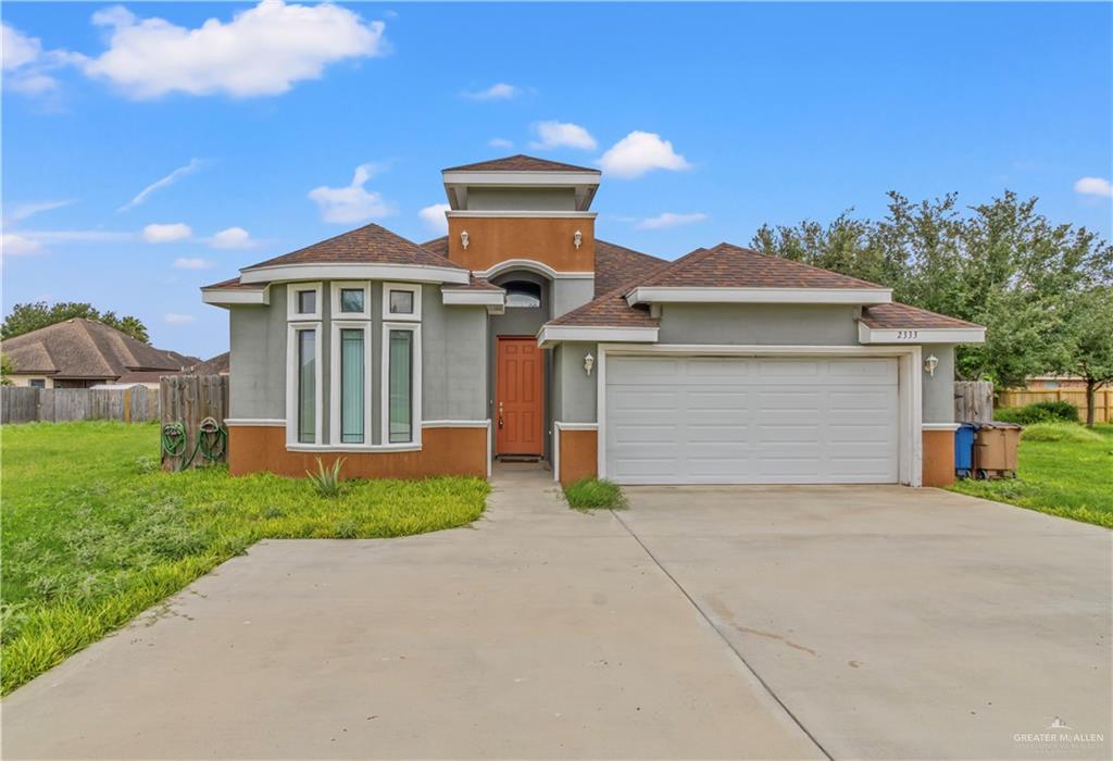 a front view of a house with a yard and garage