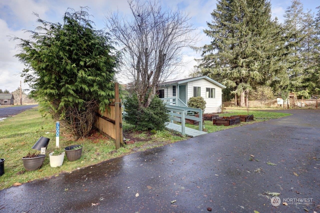 a front view of a house with a yard and trees