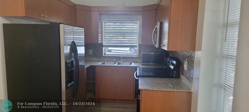 a kitchen with granite countertop a refrigerator and a stove