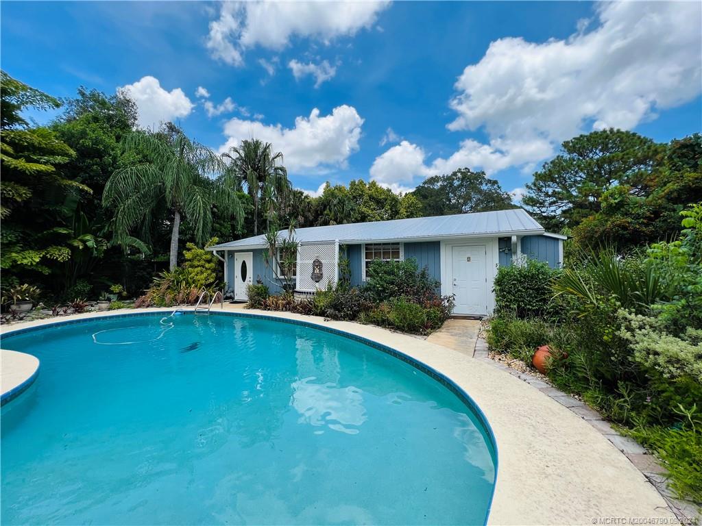 a front view of house with swimming pool and yard