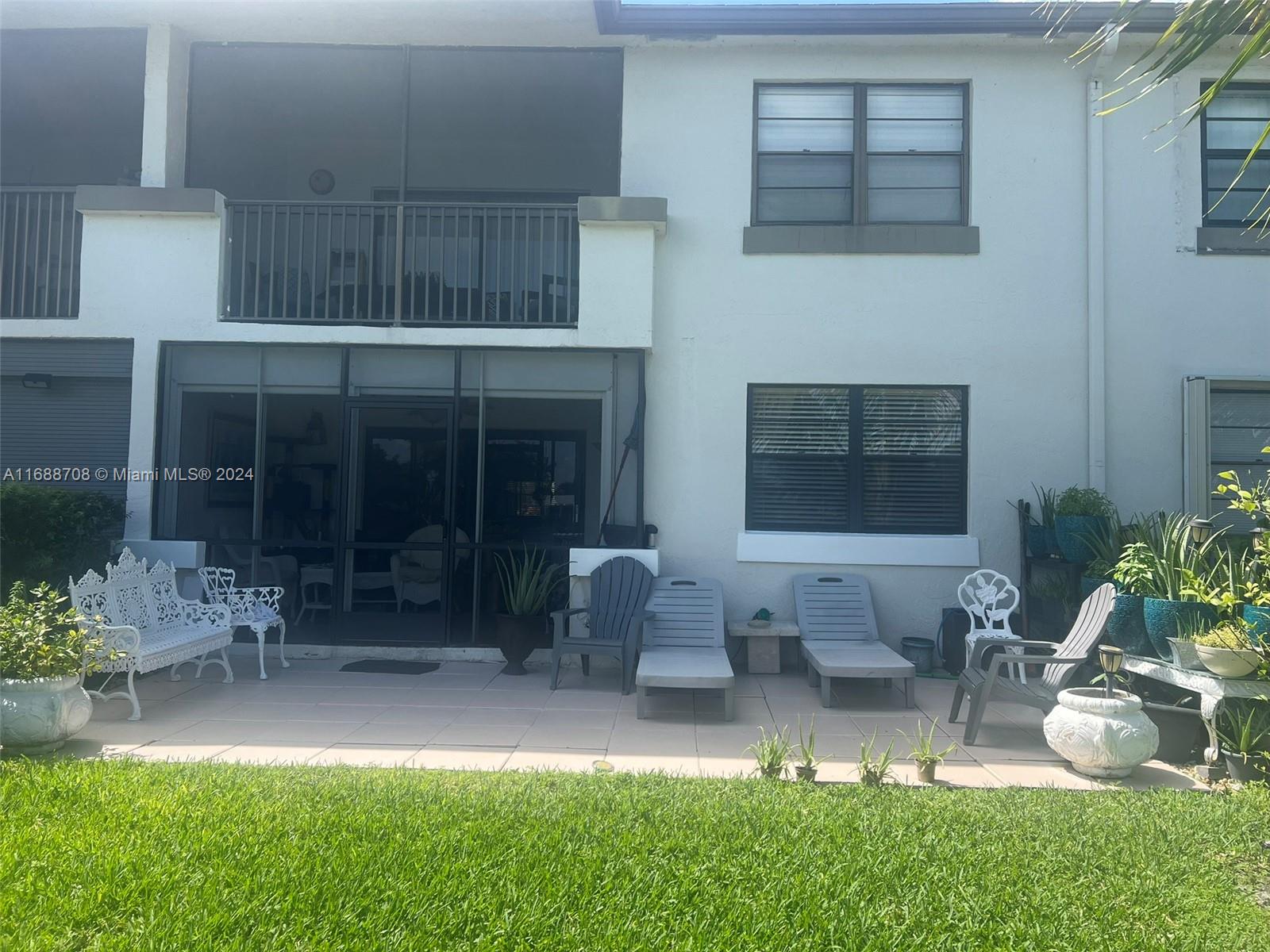 a view of house with backyard and outdoor seating