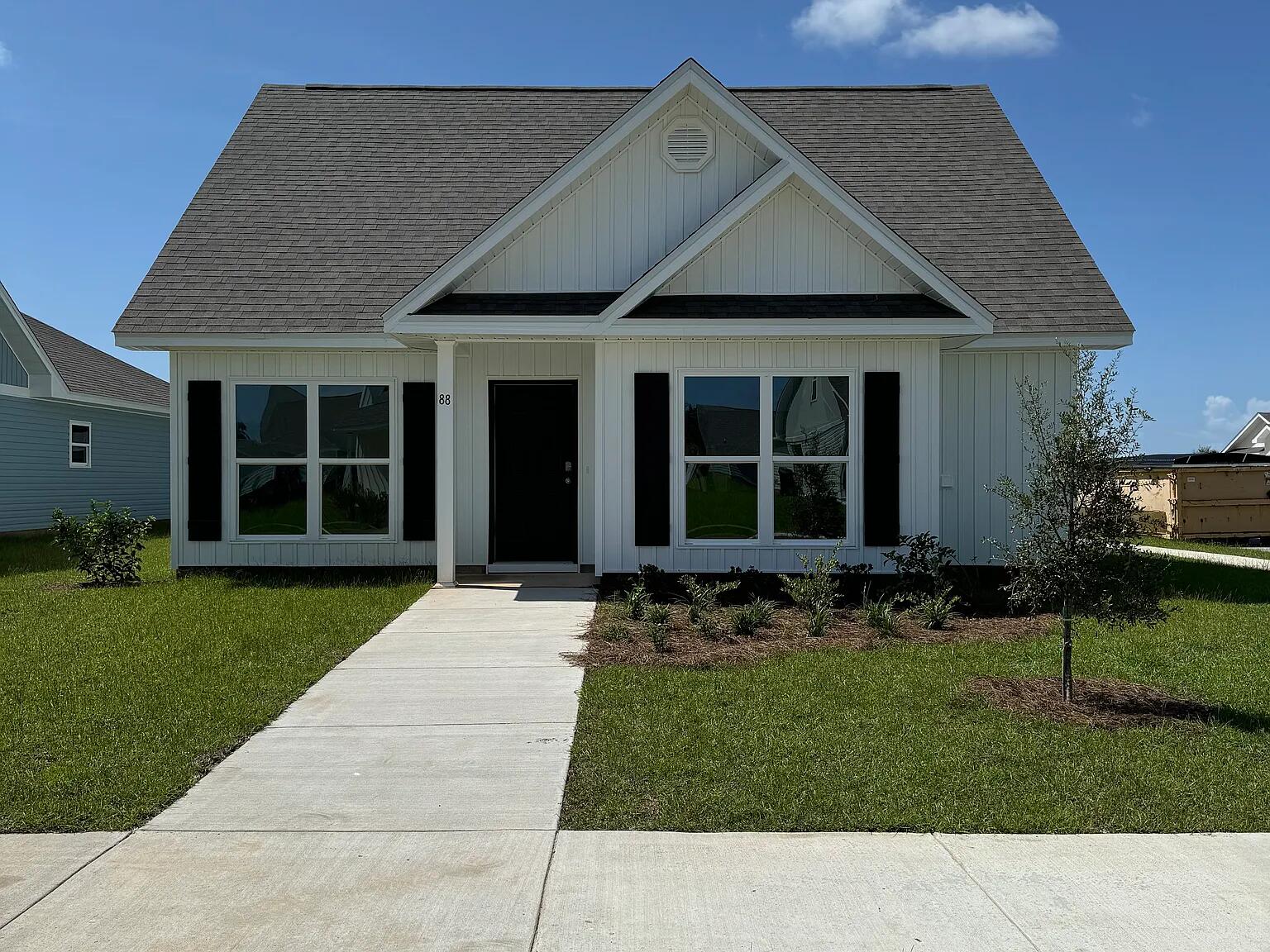 a front view of a house with a garden and yard