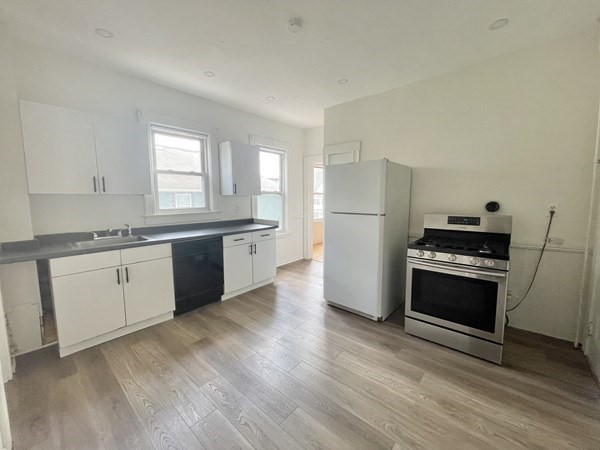 a kitchen with a refrigerator stove and wooden cabinets