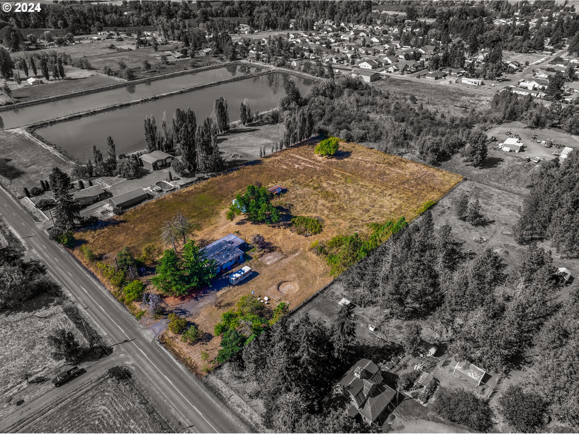 an aerial view of a house with a yard and lake view