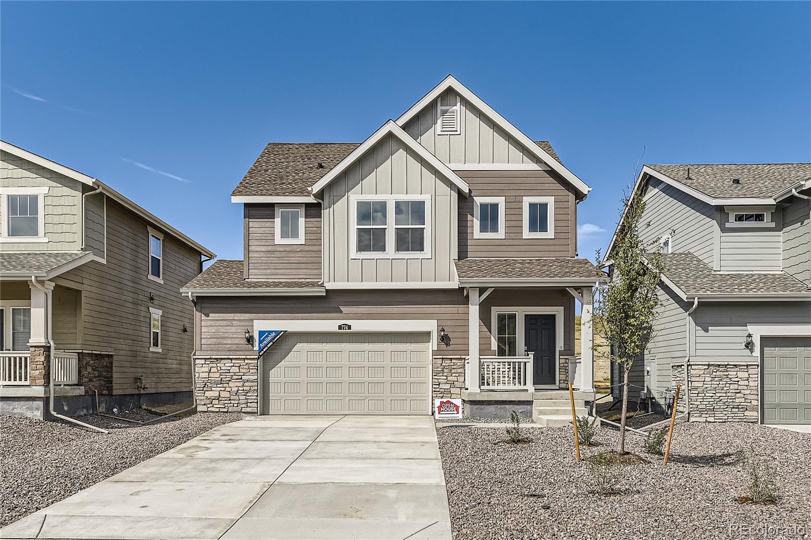 a front view of a house with yard and parking