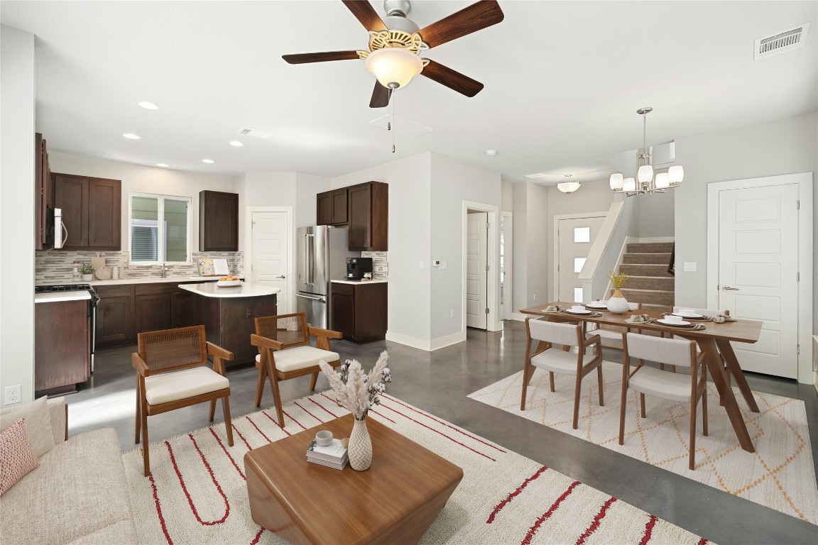 a view of a dining room with furniture a rug and wooden floor