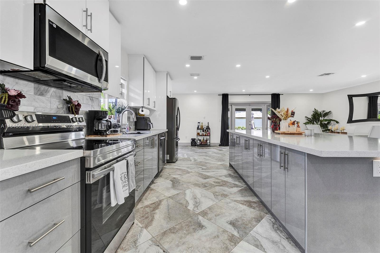 a large kitchen with stainless steel appliances lots of counter space and a sink