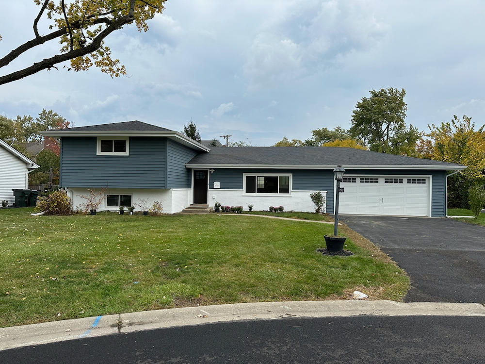 a front view of a house with a garden and yard