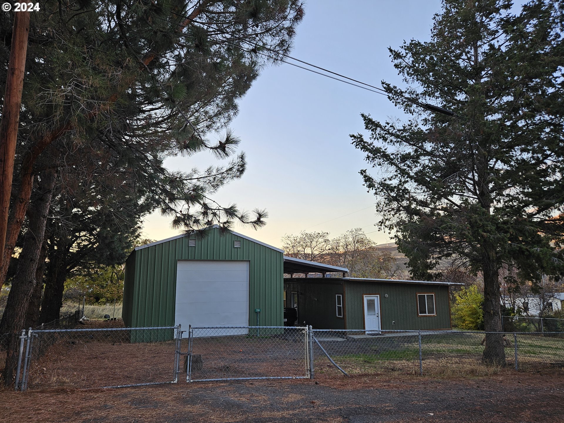 a front view of a house with a yard and large trees