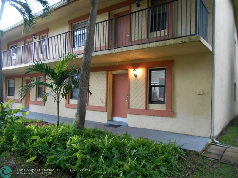 a front view of a building with plants