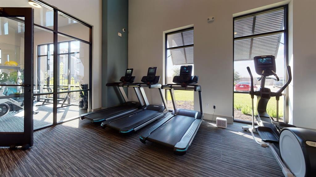 a living room with furniture gym equipment and a large window