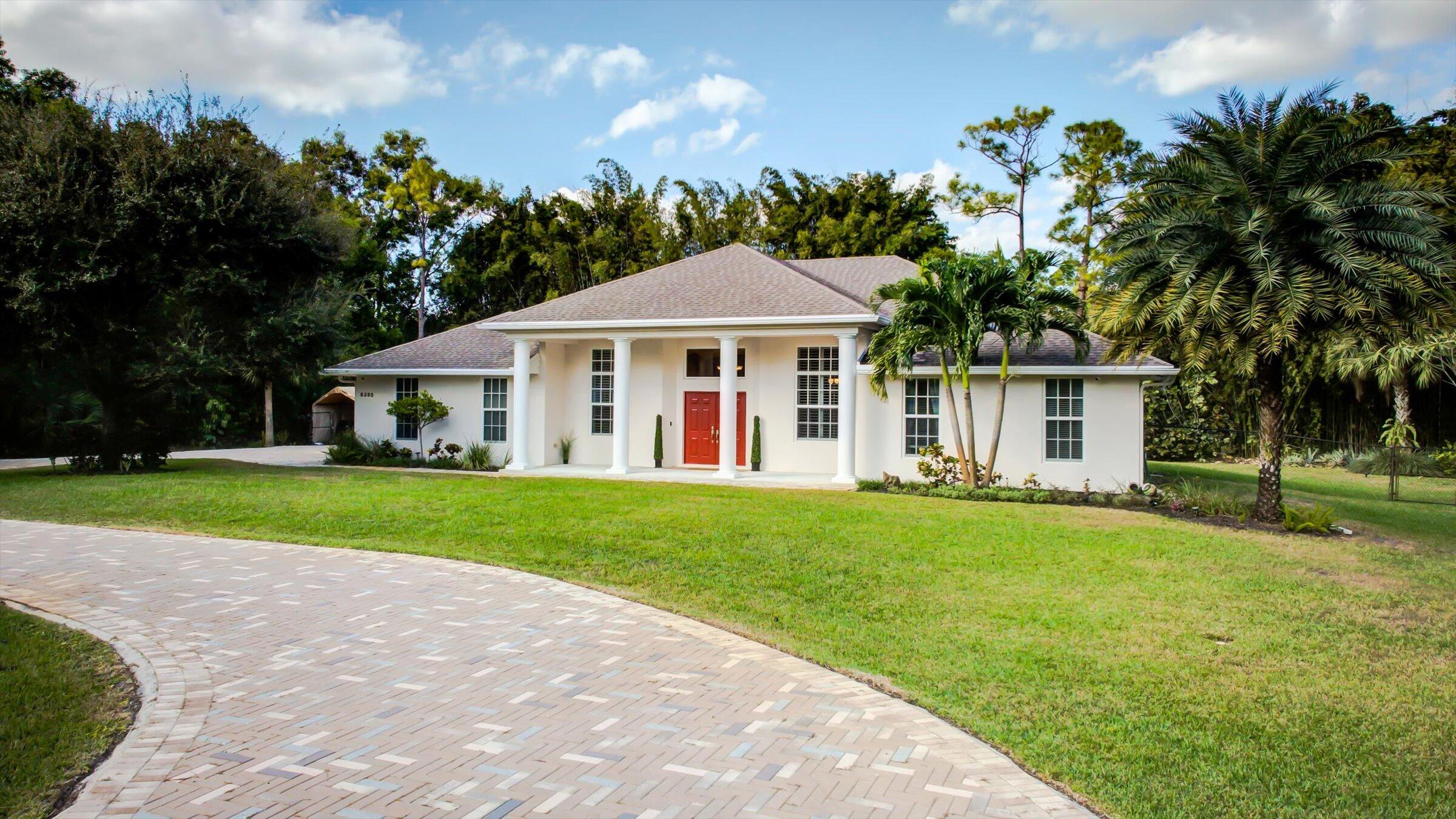 a front view of a house with a garden and trees