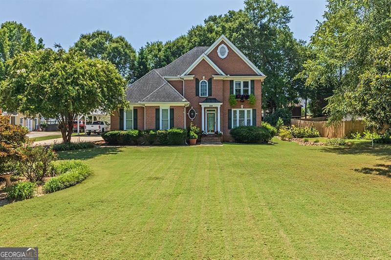 a front view of a house with a garden