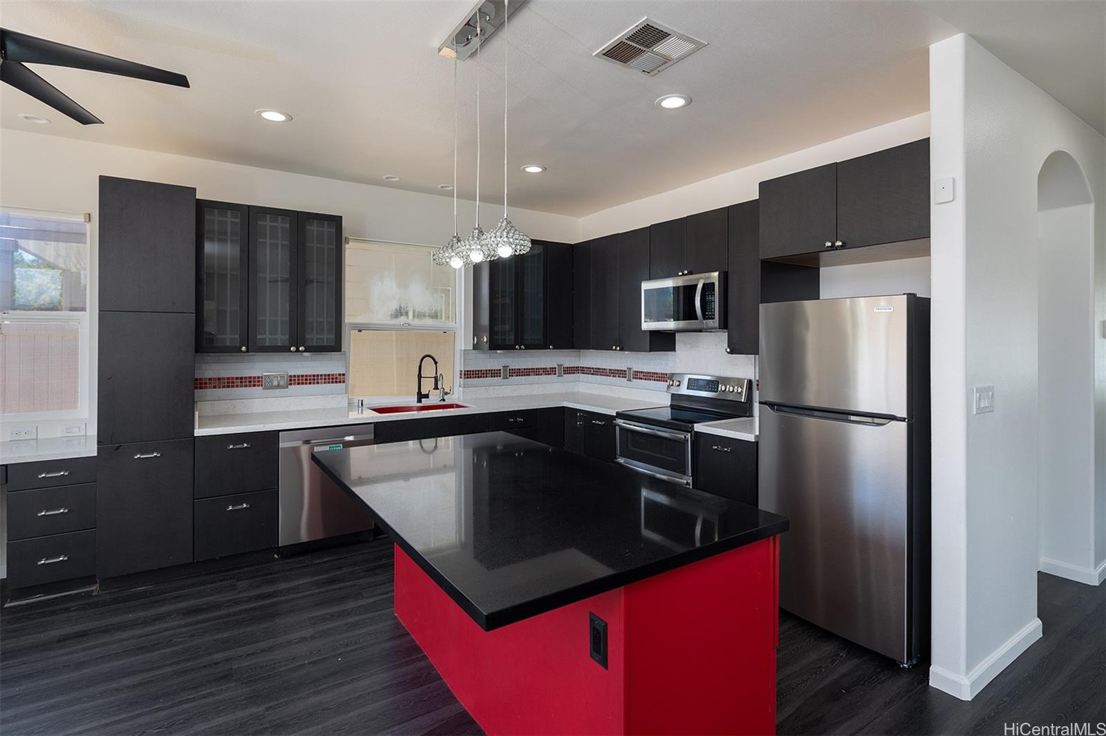 a kitchen with kitchen island a sink stainless steel appliances and cabinets