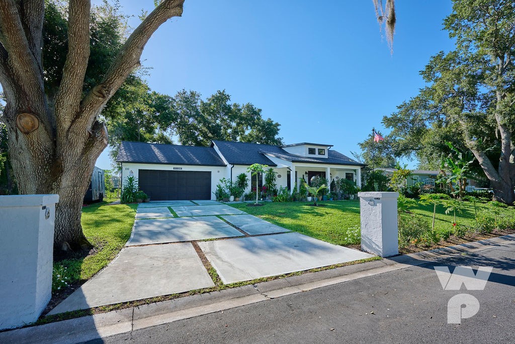 a front view of a house with a yard and trees