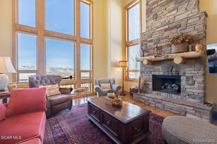 a living room with furniture large window and a fireplace